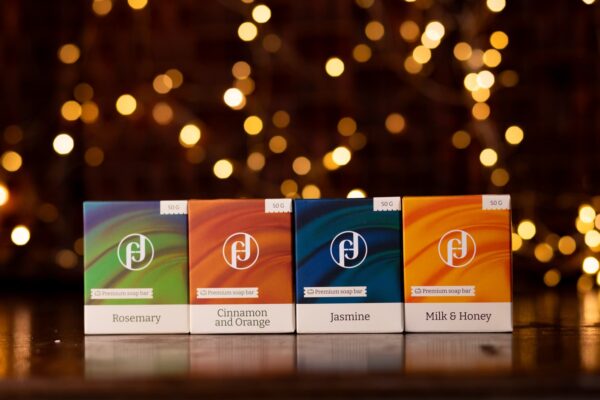 Кутия с четири ръчно изработени натурални сапуна Herbs and Flowers – Розмарин, Канела и Портокал, Жасмин и Мети Мляко, по 50 г всеки. Идеален подарък с червена панделка.